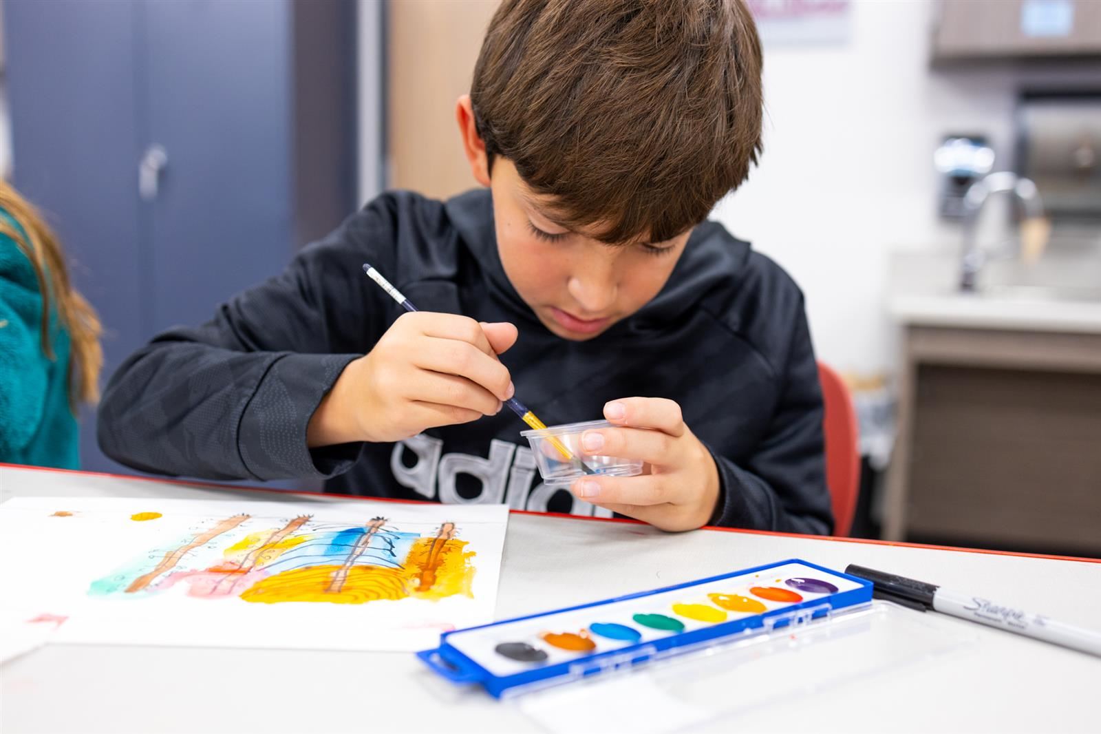 Male Student painting in Art class
